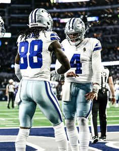 two football players standing next to each other on a field