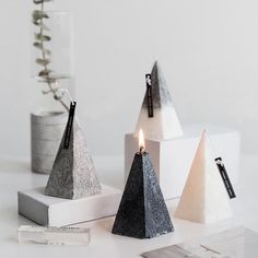 three pyramid candles are sitting on a table