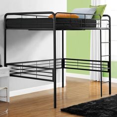 a black metal bunk bed sitting on top of a hard wood floor next to a green wall