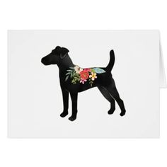 a black dog with flowers on it's back, standing in front of a white background