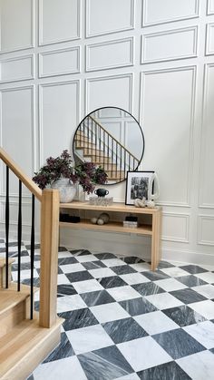 a black and white checkered floor with a mirror on the shelf next to it