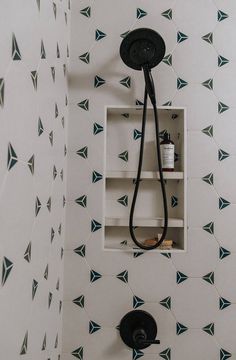 the shower head is mounted to the wall with an overhead hand showerhead and black faucet