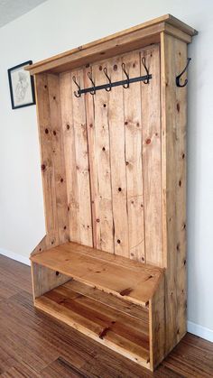 a wooden bench sitting on top of a hard wood floor next to a white wall