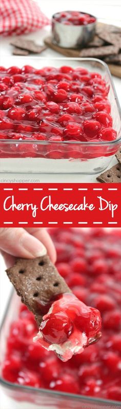 cherry cheesecake dip in a glass dish with a cracker being dipped into it