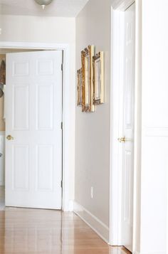 an empty room with white walls and wood floors is seen in this image from the doorway