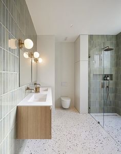 a bathroom with two sinks, a toilet and a walk in shower stall next to each other