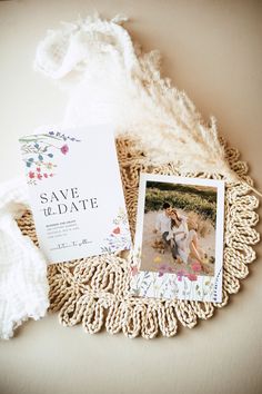 the wedding stationery is laid out on a doily with two photos and a white shawl