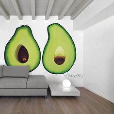 an avocado mural on the wall behind a couch in a room with wood floors