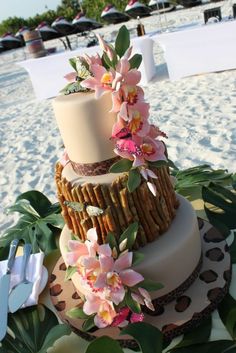 a three tiered cake with pink flowers on top