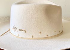 This gold on ivory floral design gives a nod to bridal bouquets and is accented by a starlet pattern surrounding the crown and a name in cursive. Each of the hats in the Flora Series have been embroidered on the customer's hat of choice and with their input on colors for the embroidery. Submit a commission request form to discuss yours! Custom designs like this one are in my level 4 price point at $425. Name In Cursive, In Cursive, Bridal Bouquets, Custom Hats, The Crown, Bridal Bouquet, Bouquets, Floral Design, Custom Design