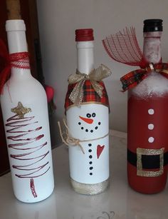 three wine bottles decorated to look like snowmen