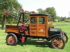 an old fashioned truck is parked in the grass