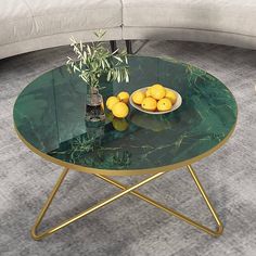 a green table with some lemons and a vase on it in front of a couch