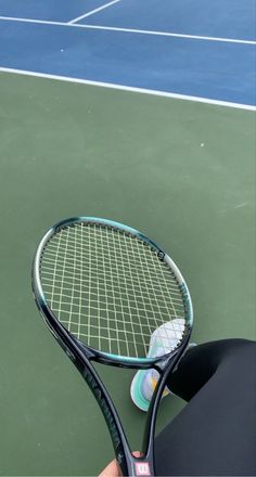 a person holding a tennis racquet on a court with the racket in their hand