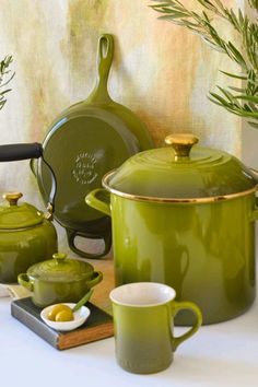 green pots and pans are sitting on a table