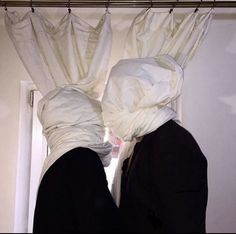 two people in black jackets with white covering their heads