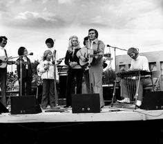 a group of people standing on top of a stage next to microphones and guitars