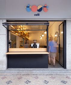 a store front with people walking in the doorway