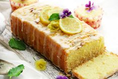 a loaf of lemon pound cake sitting on top of a table next to a cup of coffee