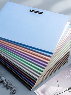 a stack of colored papers sitting next to each other on top of a white table