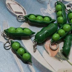 green peas are being held together by metal hooks on a blue tablecloth with flowers