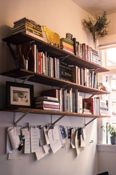 a bookshelf filled with lots of books next to a window