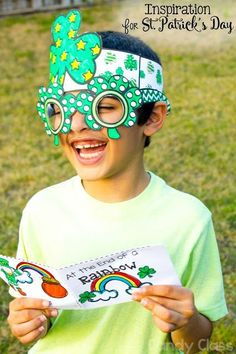 a young boy wearing a green mask and holding a book in front of his face