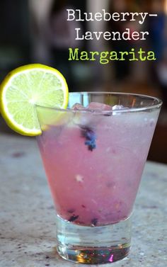 a close up of a drink in a glass with a lemon slice on the rim