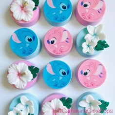 twelve pink and blue buttons with white flowers on them, all decorated in different designs