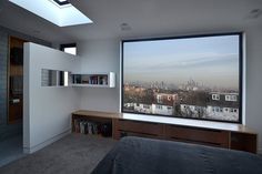 a bedroom with a large window overlooking the city