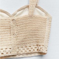 a crocheted bag hanging from a hook on a white wall with the bottom section partially closed