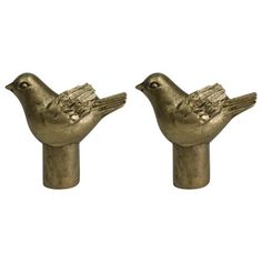 two gold colored bird figurines sitting next to each other on a white background