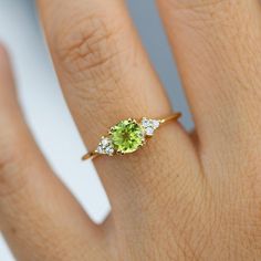 a woman's hand with a ring on it and a green stone in the middle