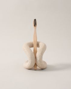 a wooden toothbrush holder sitting on top of a white surface