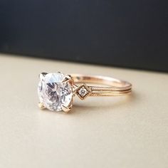 a close up of a ring with a diamond on it's side and a gold band