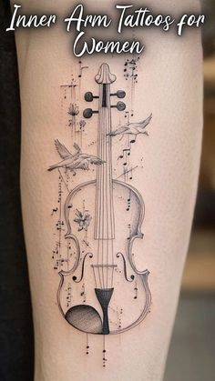 a woman's thigh with an image of a violin on it and the words inner arm tattoos for women