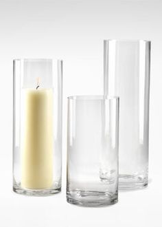 three clear glass vases with a candle in them