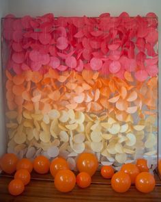 an orange and pink display with balloons in front of it