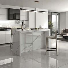 a modern kitchen with marble counter tops and white cabinets, along with two bar stools