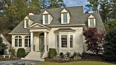 a white house with two story windows and landscaping