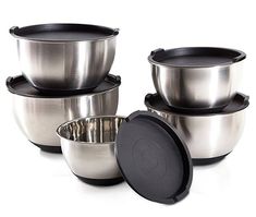 four stainless steel bowls with lids on each one and an empty bowl in the middle