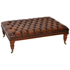 a brown leather ottoman sitting on top of a wooden table