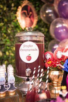 a table topped with an ice cream machine and lots of balloons