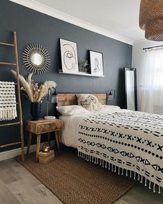 a bedroom decorated in black and white with a wooden ladder next to the headboard