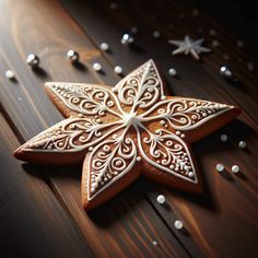 an intricately decorated gingerbread star on a wooden table with beads and stars around it