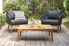 two chairs and a coffee table on a wooden deck