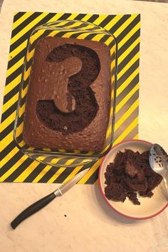 a cake with the number 3 on it and a bowl of dirt next to it