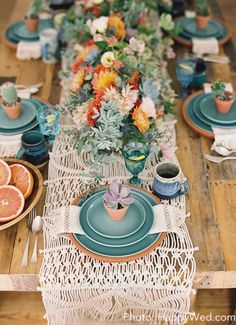 a long table is set with plates and place settings for an outdoor dinner or brunch