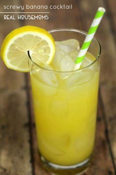 a glass filled with lemonade next to a slice of lime and a striped straw