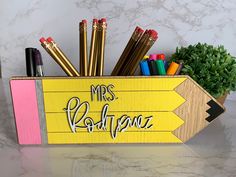 a pencil holder that has some pens and pencils in it with the words mrs buddene on it